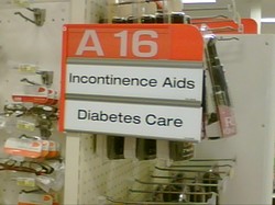 Store Isle sign that says "Incontinence Aids & Diabetes Supplies" 