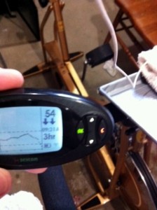 Picture of my Dexcom at 54 mg/dl with double down arrows, bike in the background